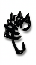 Glossy black sculptural jewelry piece: an ear cuff with curved, claw-like arms, photographed on a clean white background.