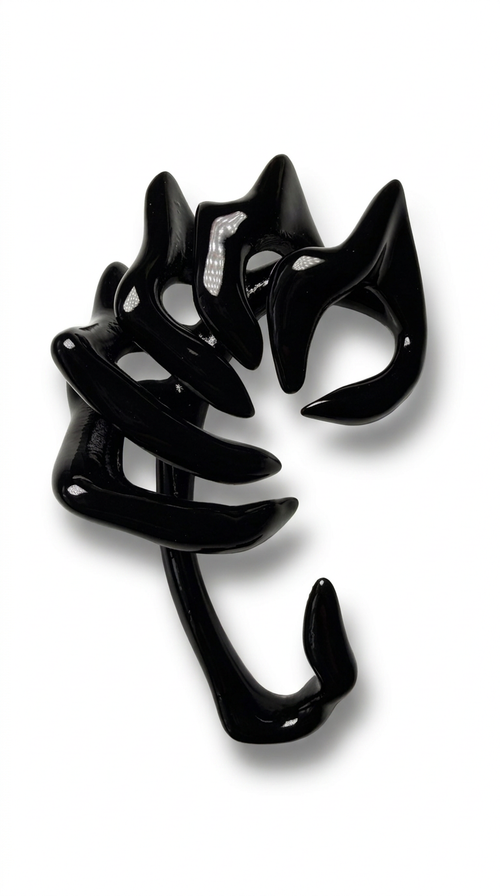 Glossy black sculptural jewelry piece: an ear cuff with curved, claw-like arms, photographed on a clean white background.